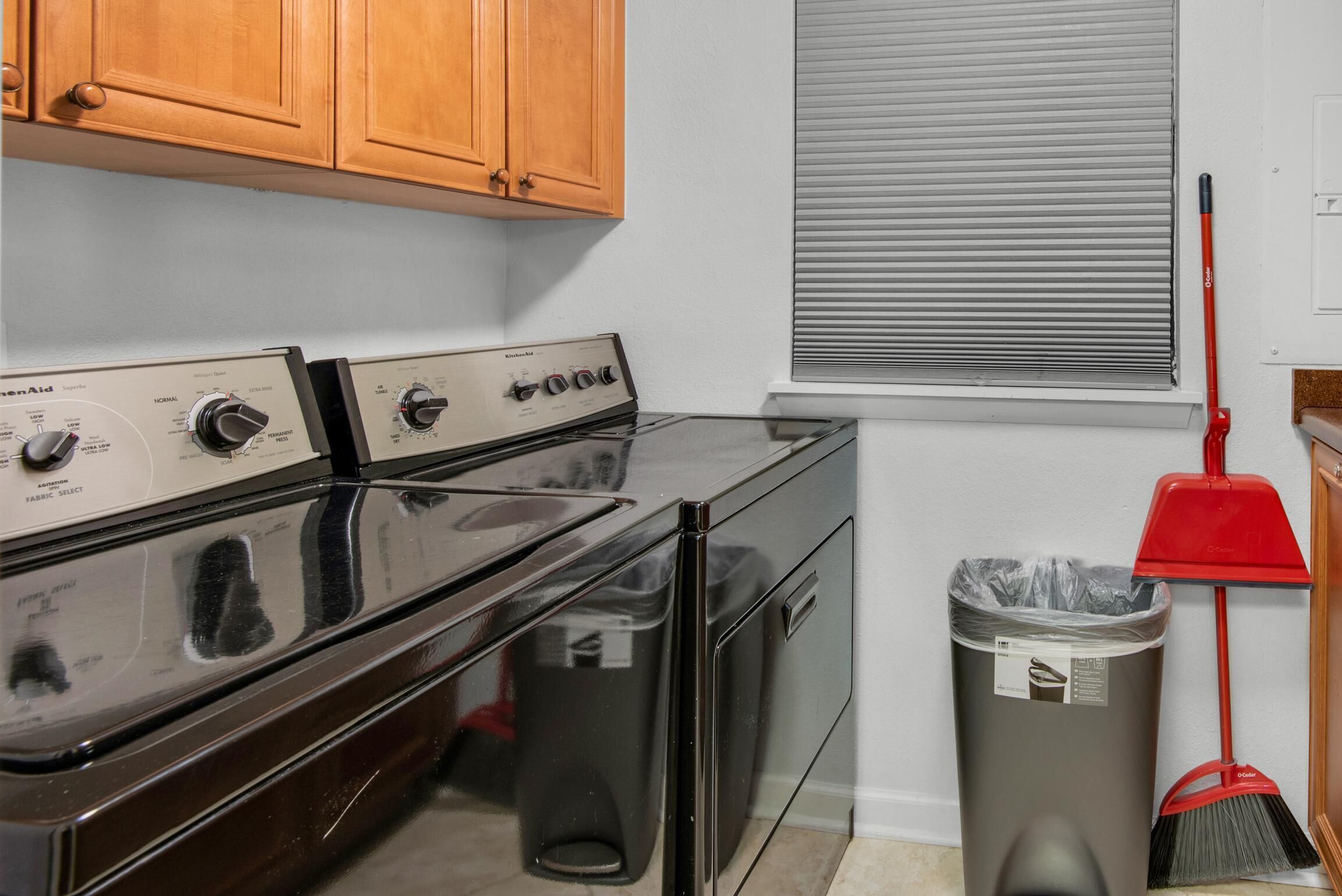 A kitchen with a stove, oven, and a trash can.