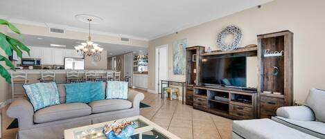 A living room with a sofa, coffee table, TV, and entertainment center.