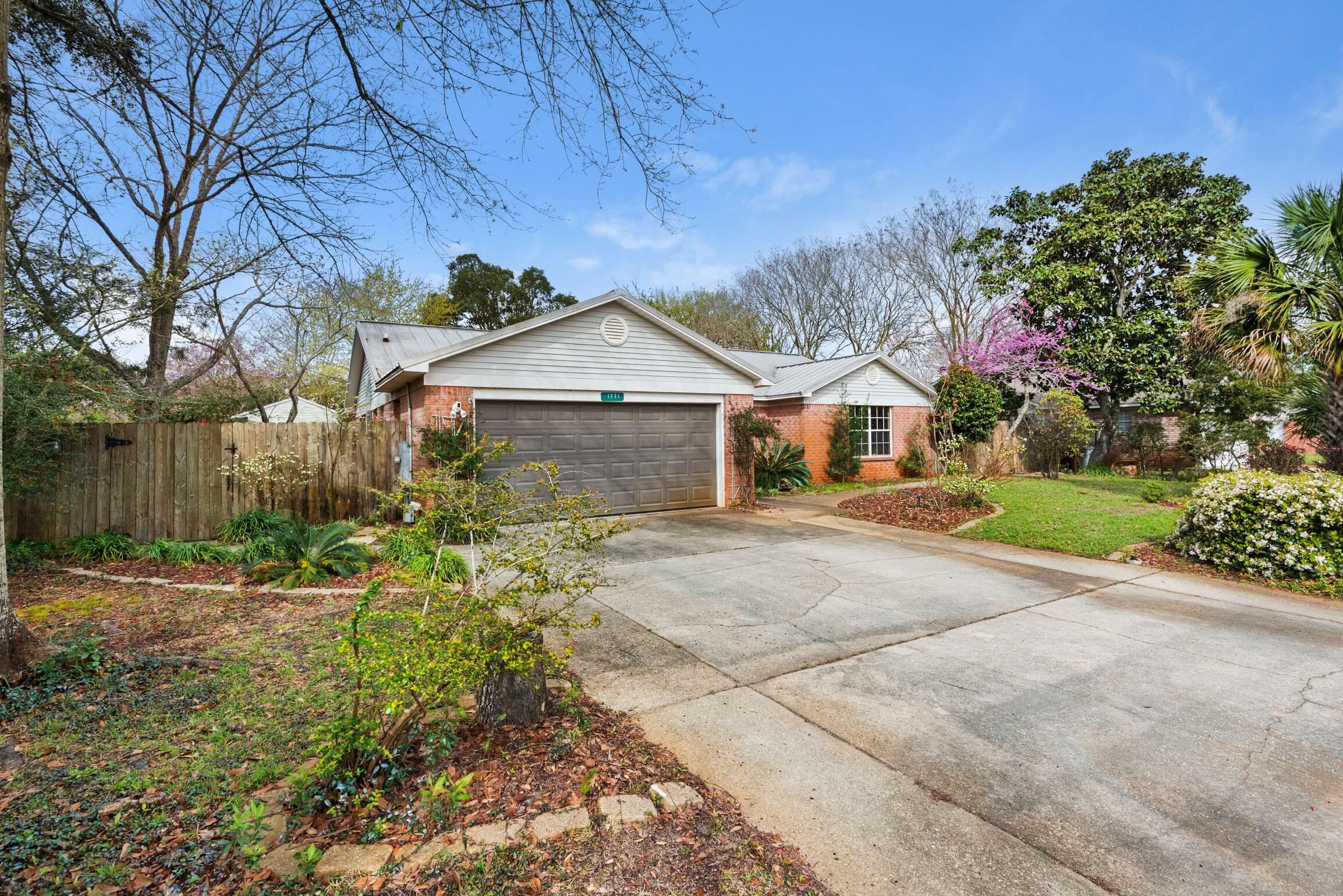 A residential house with a garage, a driveway, and a well-maintained garden.