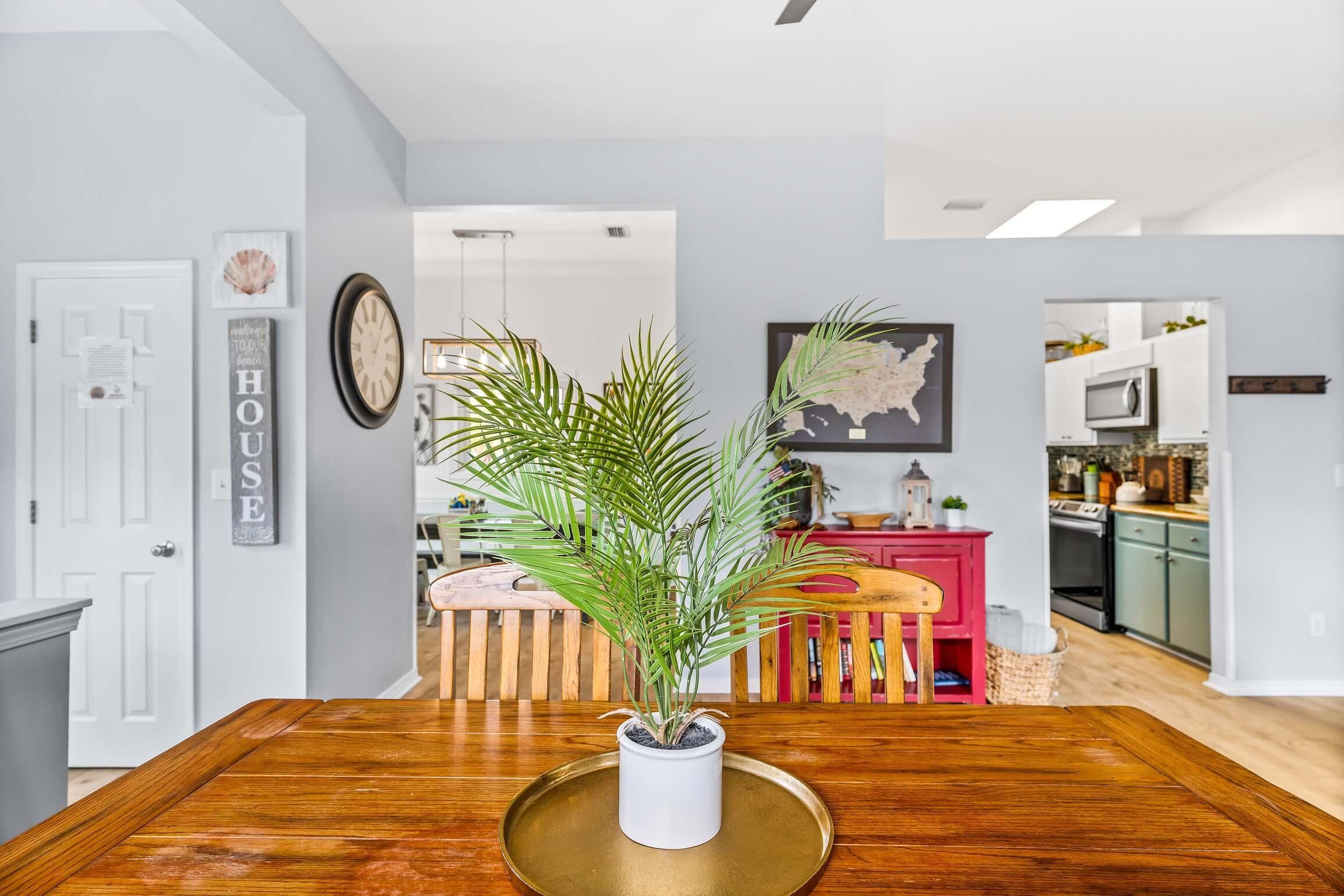 A dining area with a wooden table, a potted plant, and a map on the wall.