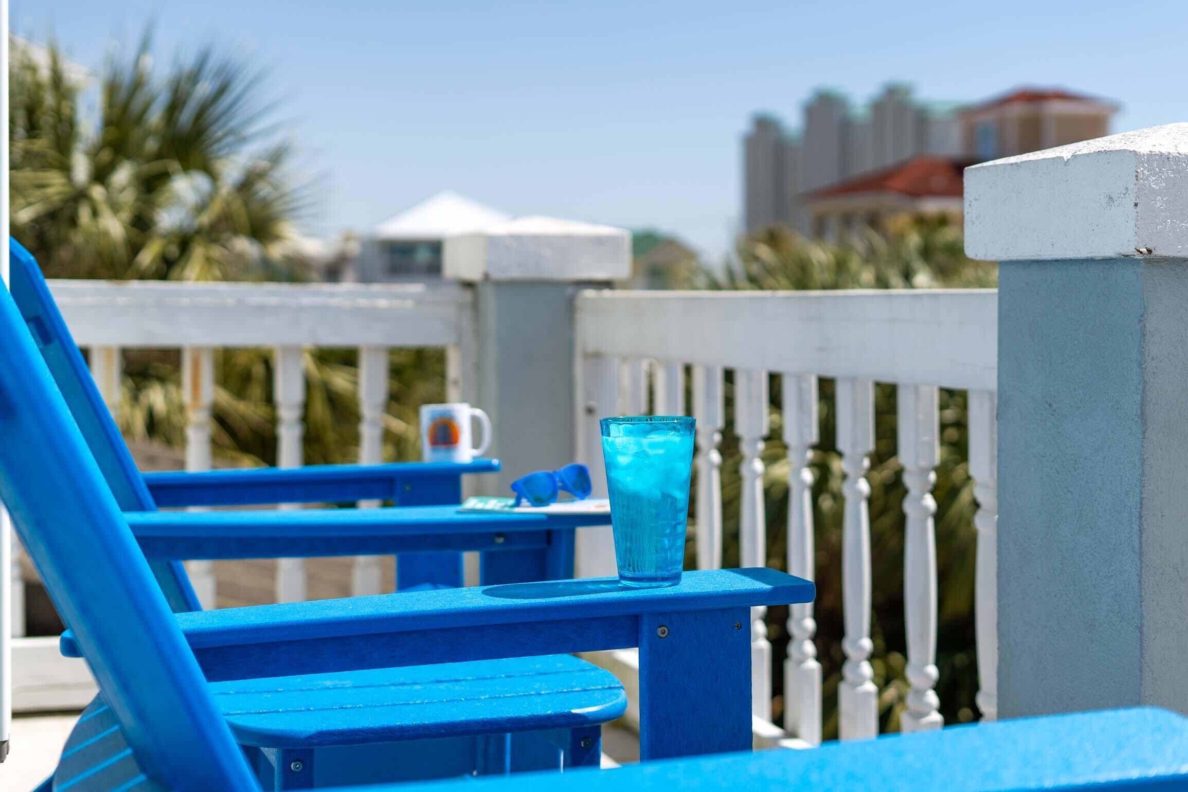 A blue outdoor seating area with a glass of water on a table.