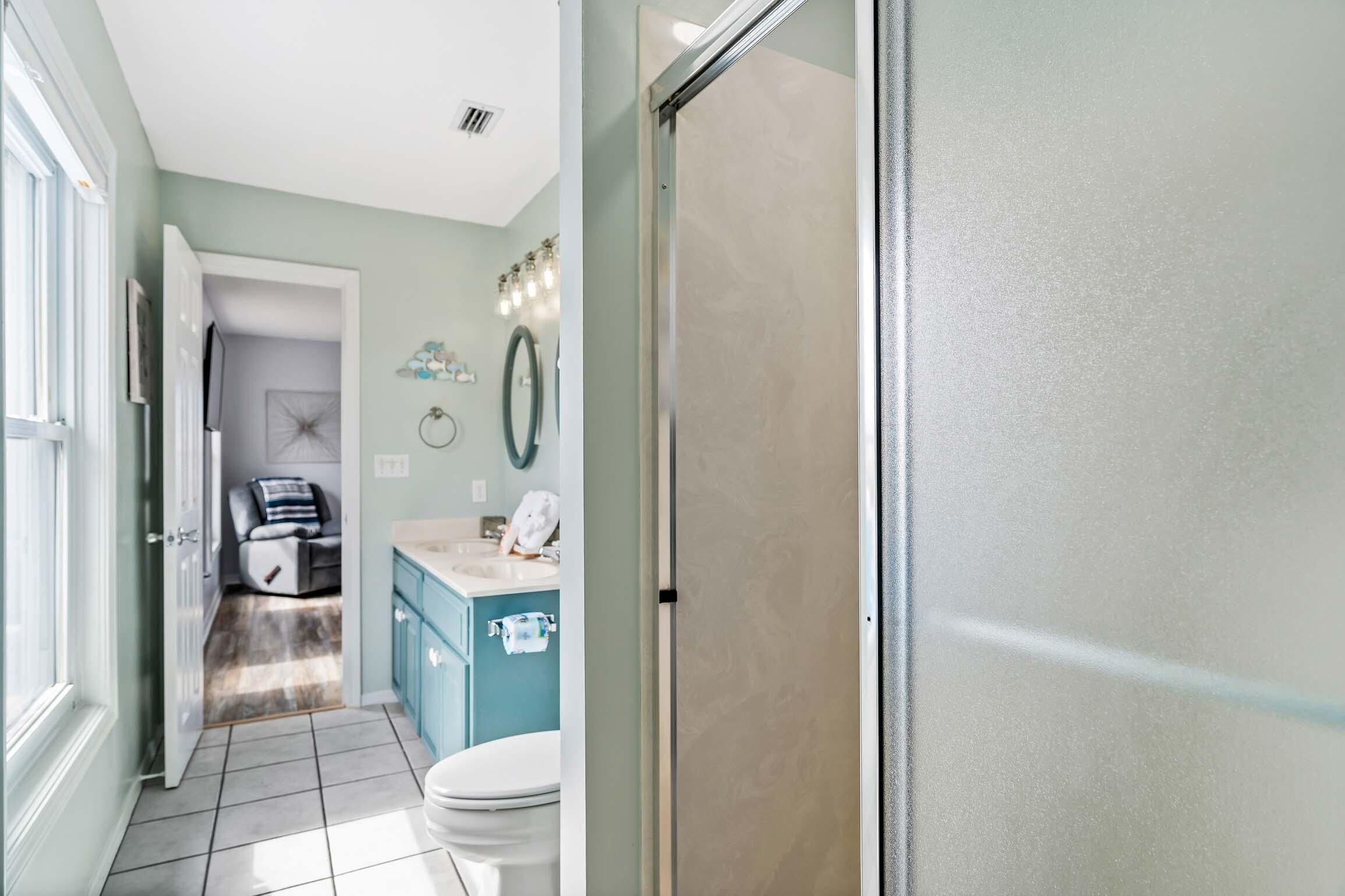 A bathroom with a toilet, sink, and shower area.