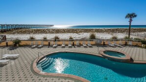 Zona de piscina con vista a la playa y al muelle.