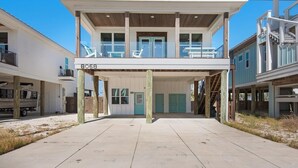 A two-story building with a covered front porch, a visible address number, and a clear sky. - Para-dise LZ (Navarre)