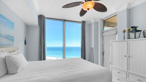 A bedroom with a large bed, a ceiling fan, and a view of the ocean. - Portofino Island Resort 5-1708 (Pensacola Beach)