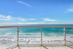 Een balkon met uitzicht op een strand en de oceaan.