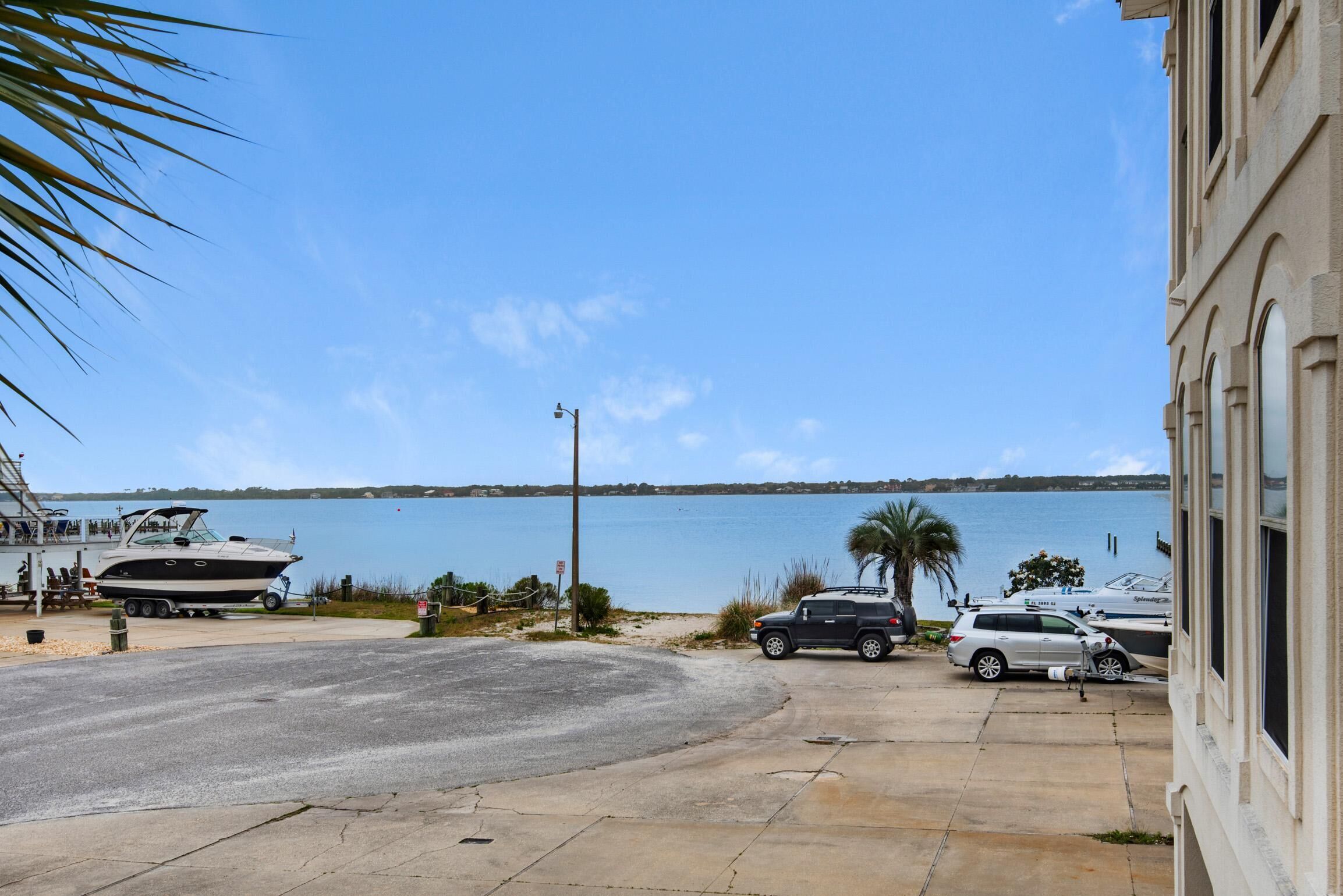 A marina with boats, a parking area, and a building with arched windows.