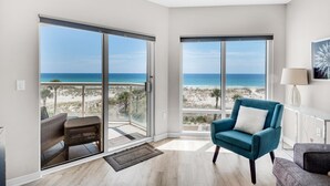 A spacious room with large sliding glass doors leading to a balcony with a beach view. - Emerald Isle Unit 206 (Pensacola Beach)