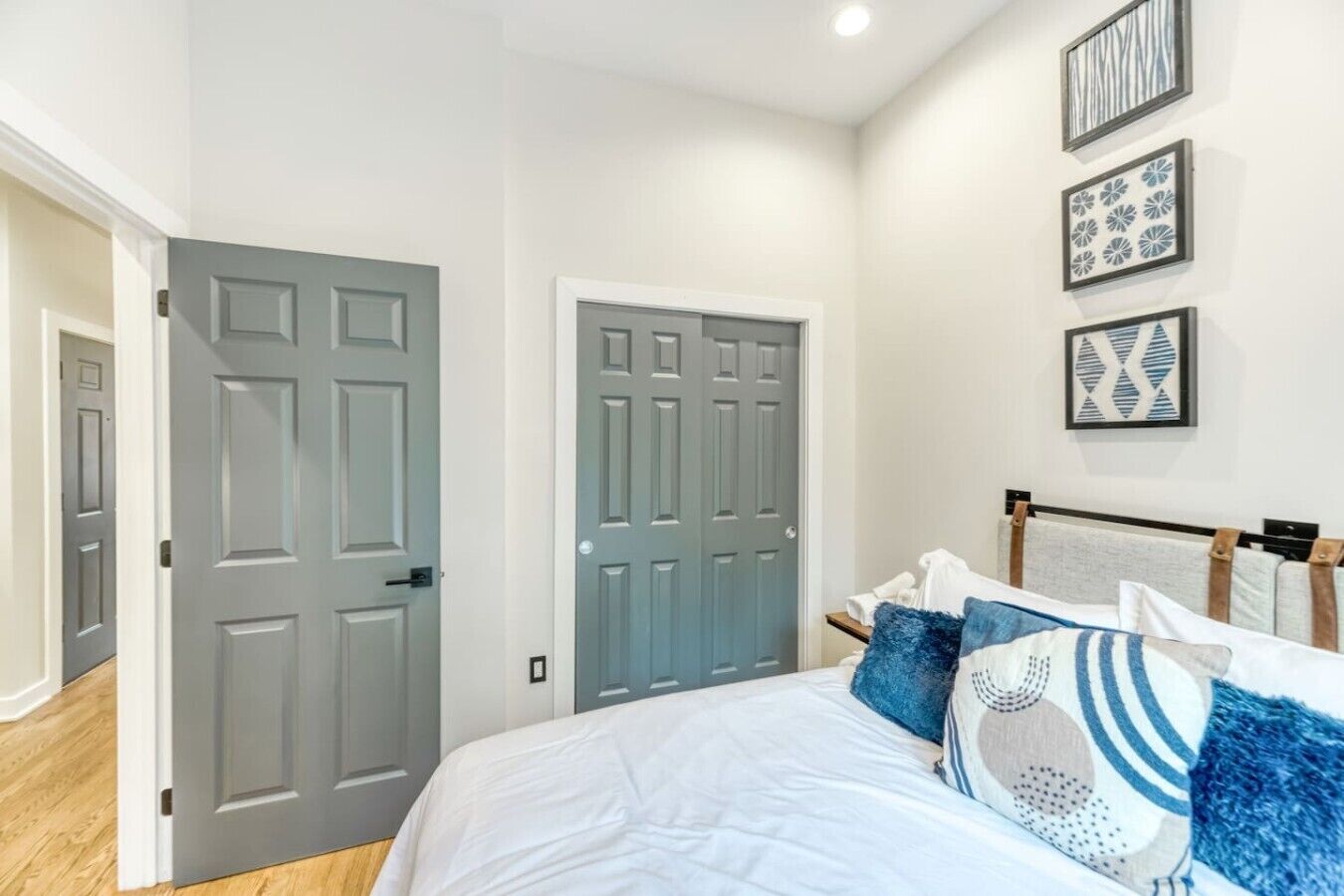 Quarto com cama, duas portas e decoração na parede.