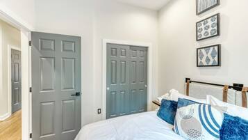 Quarto com cama, duas portas e decoração na parede.