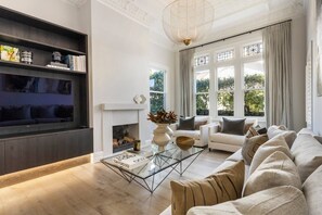 Ein modernes Wohnzimmer mit Kamin, einer Sofagarnitur, einem Couchtisch und einem Bücherregal.