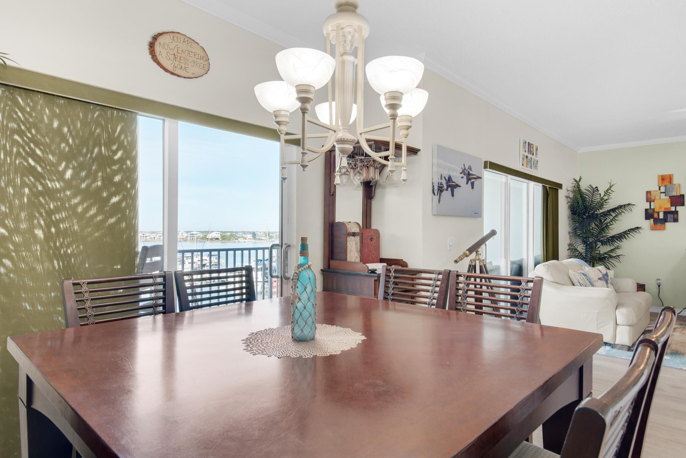 A dining area with a wooden table, chairs, a chandelier, and a decorative vase.