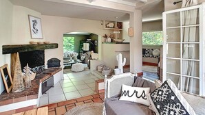 Ein gemütliches Wohnzimmer mit Kamin, Essbereich und Blick auf den Garten.