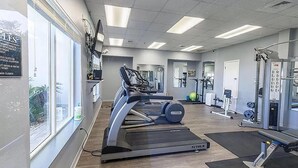 Ein Fitnessstudio mit Laufbändern, Gewichten und Trainingsgeräten.