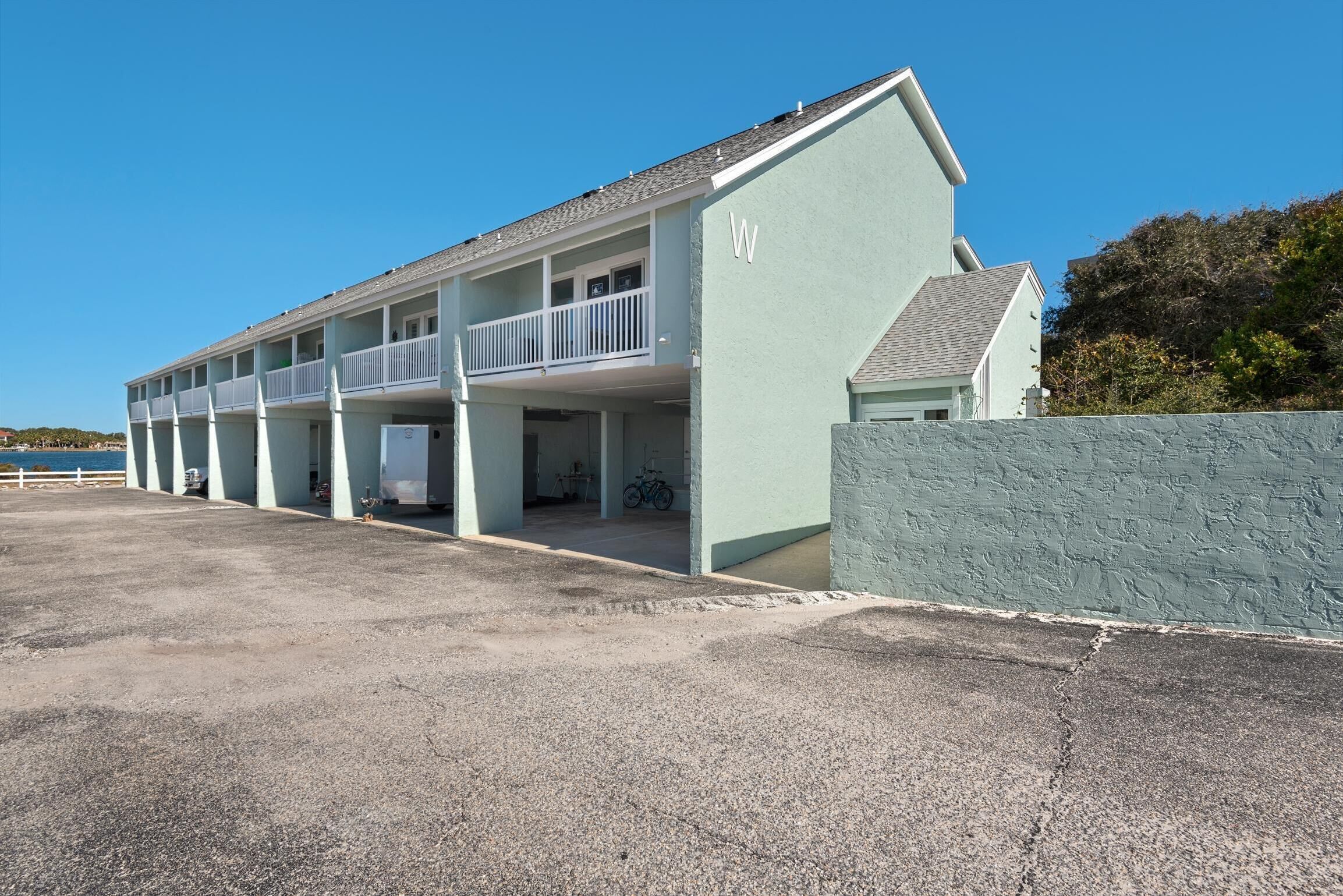 A motel with a light blue exterior, multiple balconies, and a parking area.