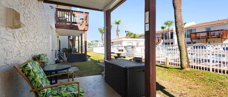 A covered patio with outdoor furniture, a pool, and a view of the surrounding neighborhood.