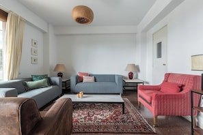 Un salon comprenant un canapé, un fauteuil, une table basse et des lampes.