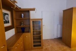 Um quarto com móveis de madeira, uma porta branca e um guarda-roupa.