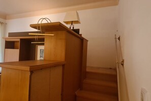 A wooden staircase leading to a landing with a lamp and a coat rack. - Cozy City Center Retreat 2BR Apt. Homelike Comfort (Vienna)