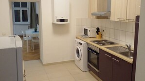 A compact kitchen with a washing machine, a microwave, and a sink.