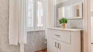 A bathroom with a white vanity, a mirror, and a potted plant. - Cheerful 2BR Apartment - Suitable for Longstays (Vienna)