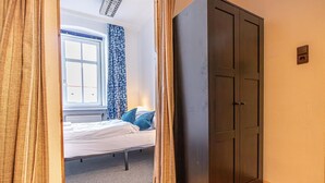 A bedroom with a bed, a window with curtains, a wardrobe, and a radiator. - Vienna's Finest: Spacious Apt. w/2+1 Configuration (Vienna)