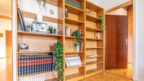 A room with a wooden bookshelf, a clock, and a door. - Vienna's Finest: Spacious Apt. w/2+1 Configuration (Vienna)