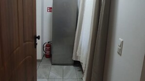 A narrow hallway with a closed door, a fire extinguisher, and a curtain. - Enkplatz U3 Getaway: Affordable 5-BR Apartment (Vienna)