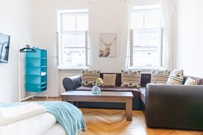 A living room with a sofa, a coffee table, a TV, and a blue storage unit.