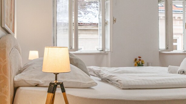 Ein Schlafzimmer mit einem Bett, einer Nachttischlampe und einem Fenster.
