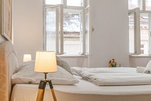 Une chambre à coucher avec un lit, une lampe de chevet et une fenêtre.