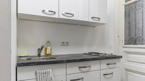Eine kleine Küche mit Spüle, Arbeitsplatte und Schränken.
