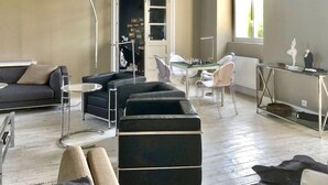 Una sala de estar moderna con un sofá, sillas, una mesa de centro y un tablero de ajedrez.