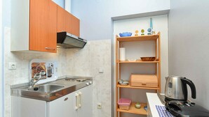A compact kitchen with a sink, stove, and a coffee maker. - Holiday apartment with air conditioning (Fažana)