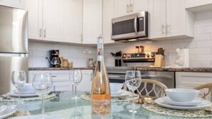 A modern kitchen with white cabinets, a stainless steel refrigerator, and a microwave. - BoHo Chic Suite - Long Stays - Fireplace - Garage
 (Edmonton)