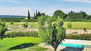 A pool area with a clear view of the surrounding landscape, including a grassy field, trees, and distant hills. - Stunning home in Maillane with WiFi (Maillane)