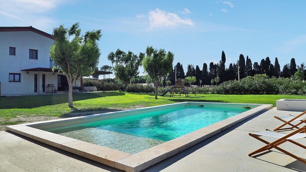 A swimming pool with a clear blue water, surrounded by a concrete deck. There are lounge chairs and a small table on the deck. - Stunning home in Maillane with WiFi (Maillane)