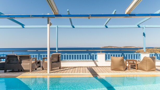 Ein Poolbereich mit Liegestühlen und Meerblick.