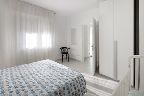 Una camera da letto con un letto, una sedia e un armadio.