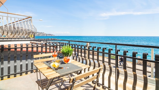 Una terraza con una mesa preparada para dos, con vista al mar.
