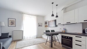 Eine moderne Küche mit weißen Schränken, einer schwarzen Arbeitsplatte und einem eingebauten Backofen.