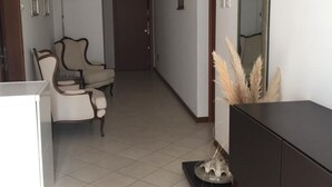 A hallway with a dining area, a dark-colored dresser, a mirror, and a lamp.