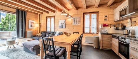 Un interior de madera con comedor, cocina y zona de estar.