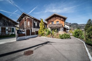 A street view with two wooden buildings, one with a balcony, and a clear sky.