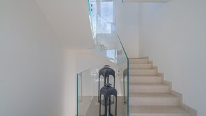 En moderne trappe med glasgelændere og et minimalistisk design.