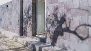 En moderne bygning med en stenfassade, en dør og et lille vindue.