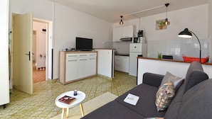 A compact living space with a kitchenette, a sofa, a small table, and a TV. - Holiday apartment with air conditioning (Rabac)