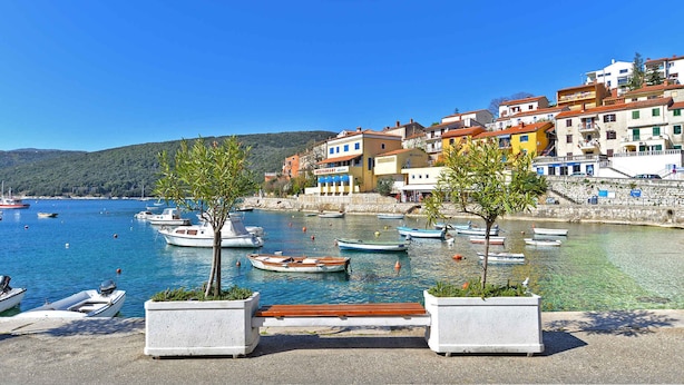 A coastal town with colorful buildings, a marina with small boats, and a clear blue sky. - Holiday apartment with air conditioning (Rabac)