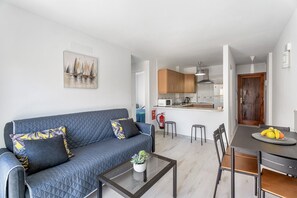 Un salon moderne avec un canapé, une table basse et un coin repas.