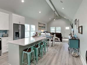 A spacious kitchen with a large island, bar stools, and a dining area. - Holiday Hideaway by Miss Kitty’s (Rockport)